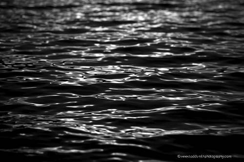 black and white photo of late evening sunlight on the waves